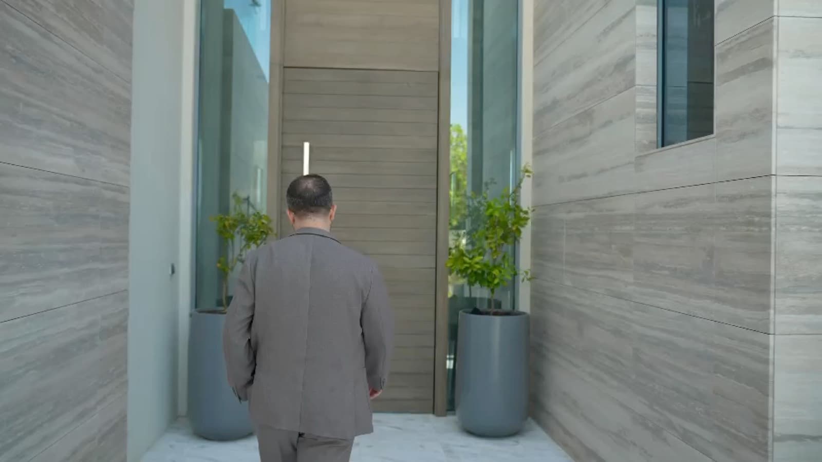 An agent walking to the entrance of a Saadiyat Island villa, from a OneByOne listing film